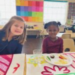 two young girls eating lunch at school