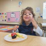 young girl eating cupcake