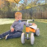 young boy playing with a bike outside