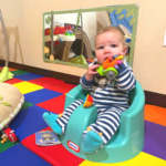 baby chewing on toy in classroom