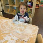 little girl playing with paste