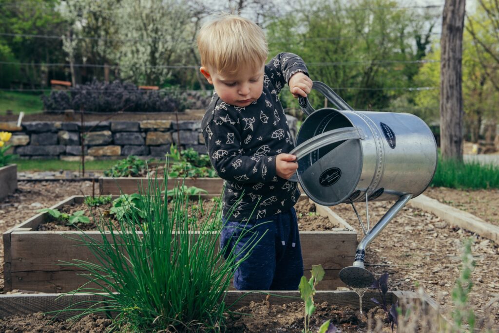 child watering garden