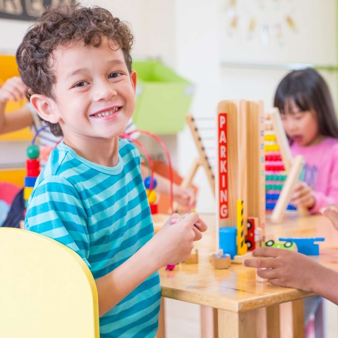 Smiling child playing with toys in a classroom