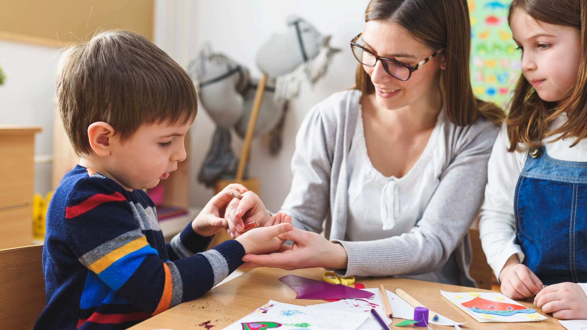 Teacher helping students with craft project