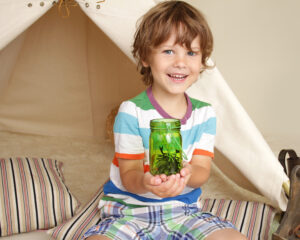 child holding a jar in a tent