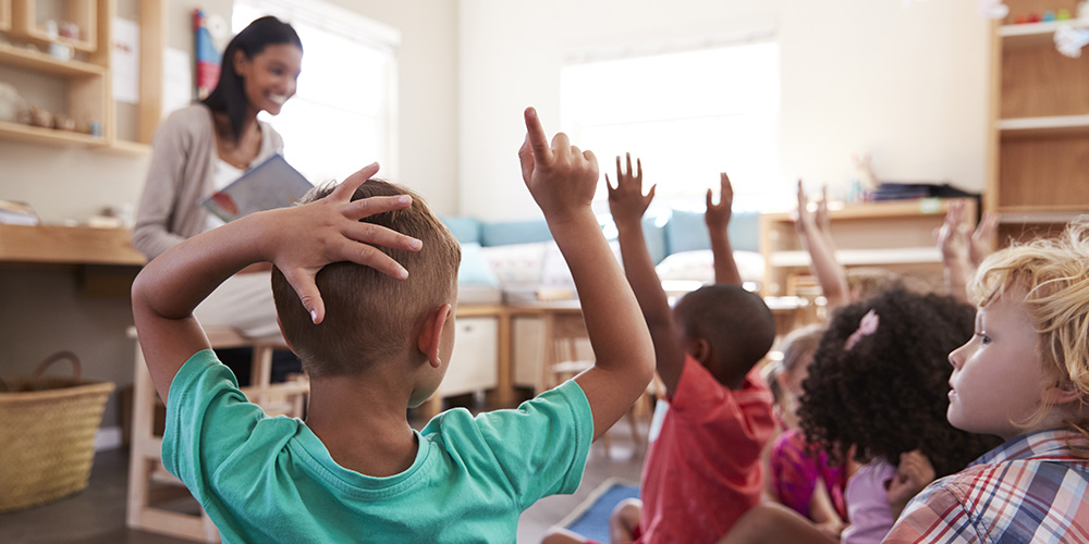 children Raising Hands To Answer Question