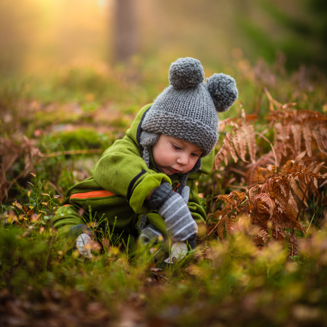 little boy playing in the leaves