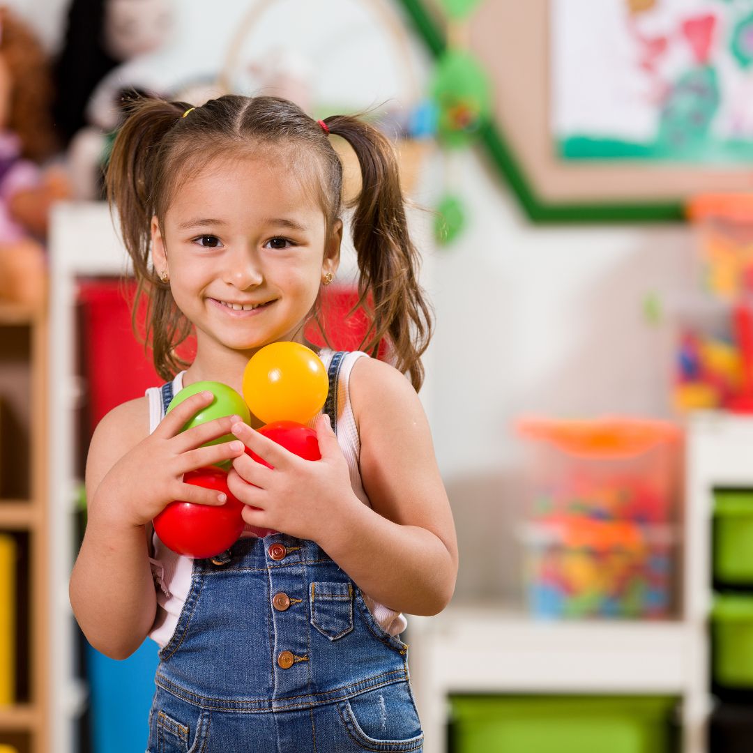 preschooler holding colorful balls