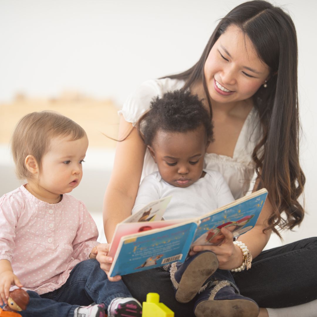 a teacher reading a book to children