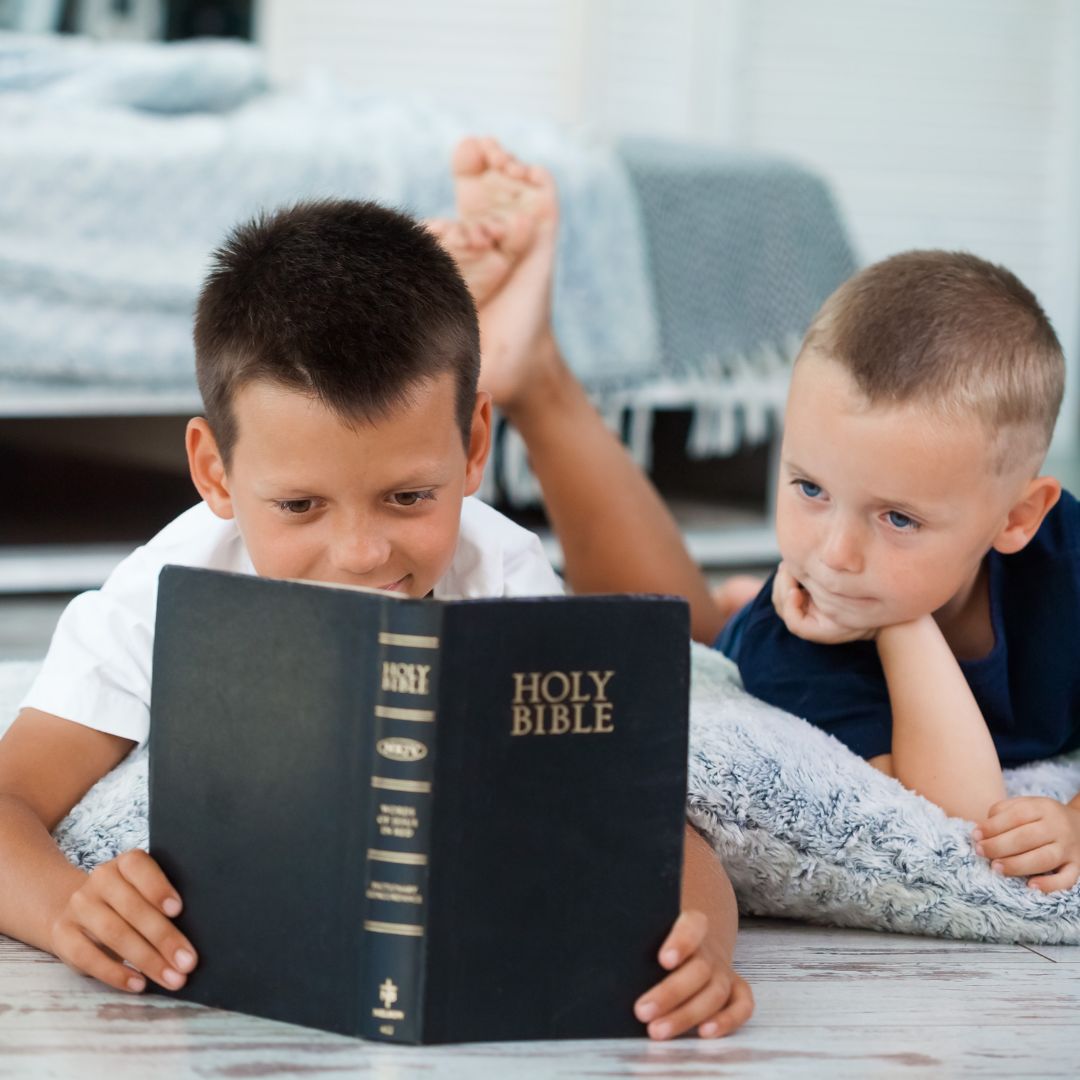 two boy reading a bible