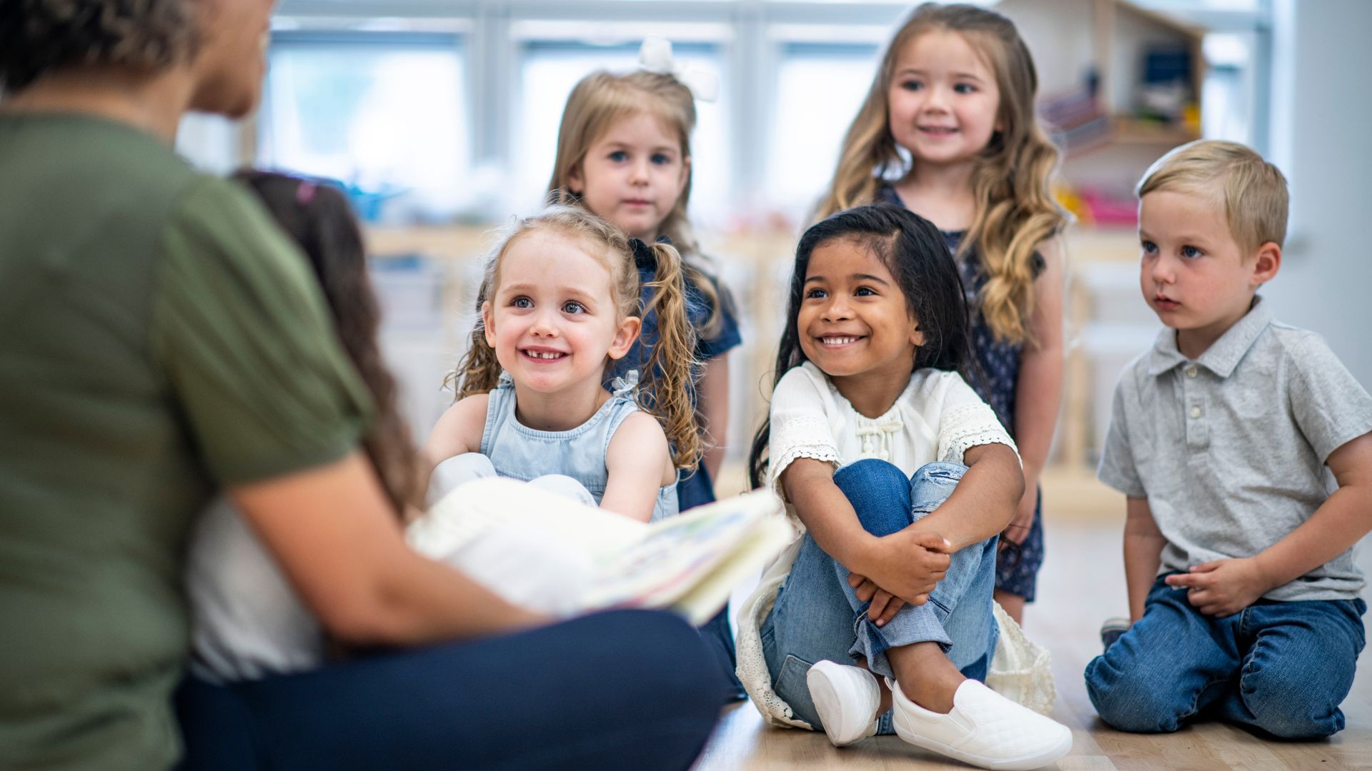 smiling children listening as a book is being read