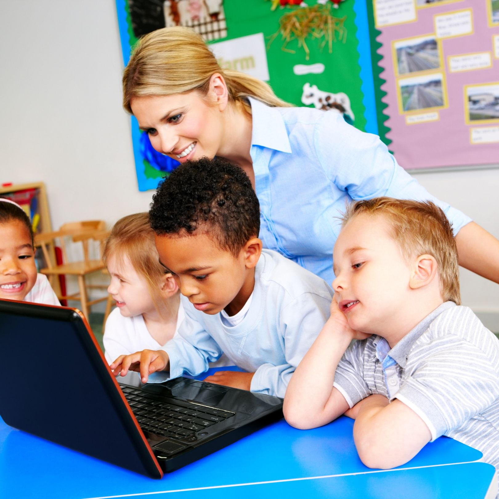 children at computer with teacher