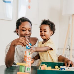 teacher and child playing with blocks