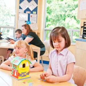 girls playing with a toy house
