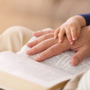 child reading bible with parent