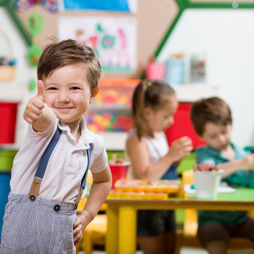 boy giving a thumbs up in classroom