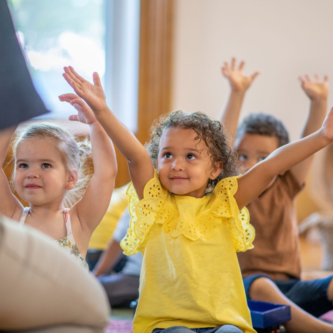 classroom children with raised arms