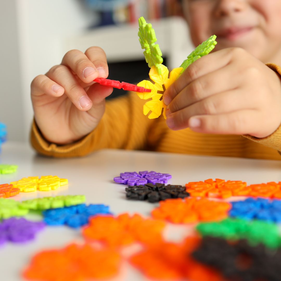 child assembling building toy