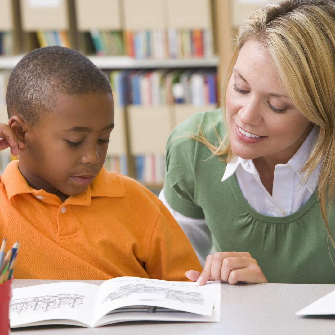 teacher helping child with workbook