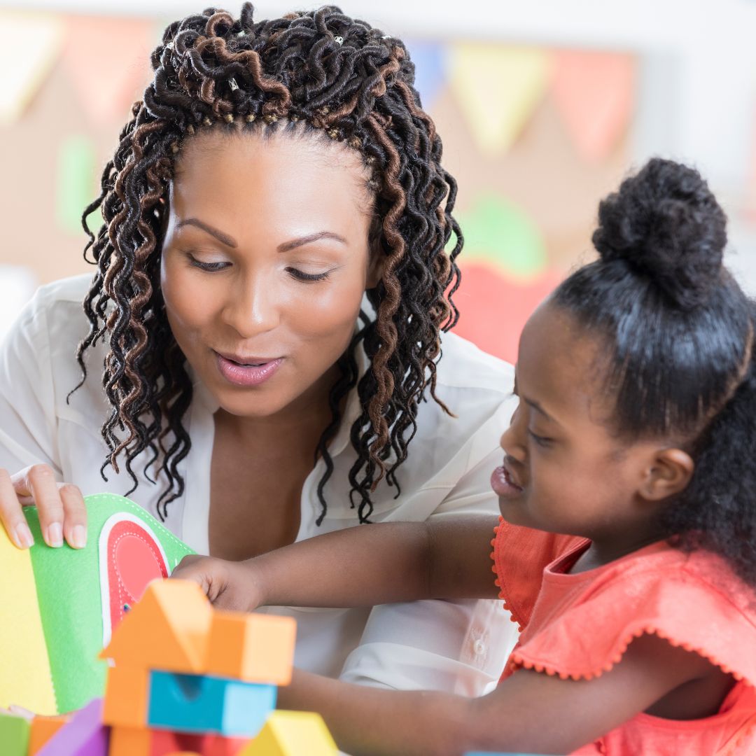 teacher watching child build with blocks