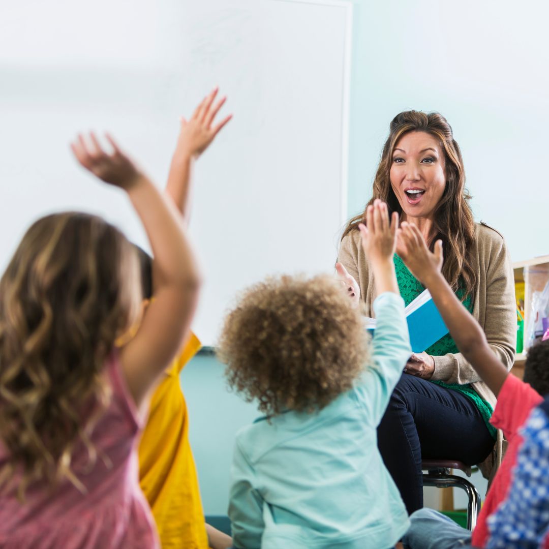 children raising hands in class