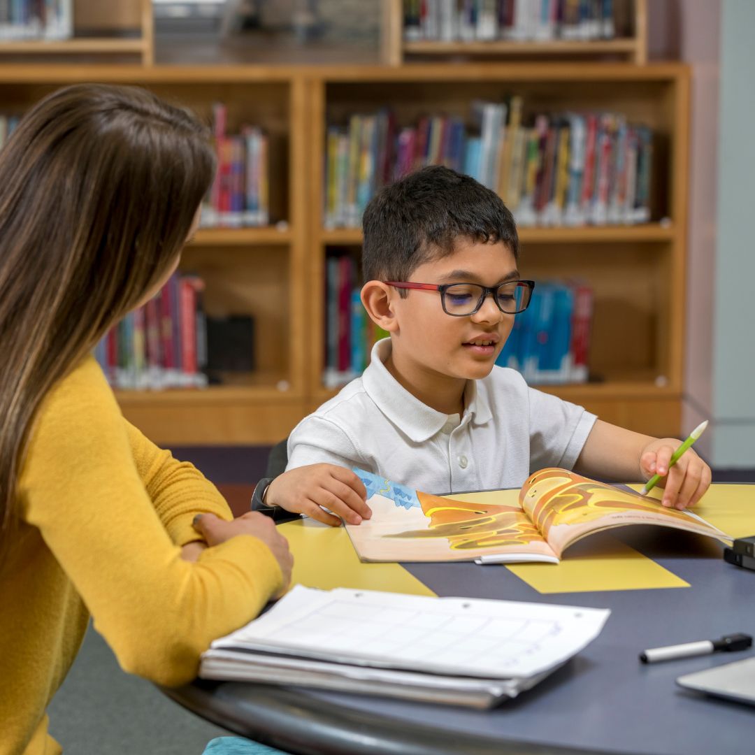 child reading, teacher observing