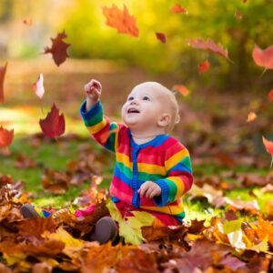 Baby catching falling leaves