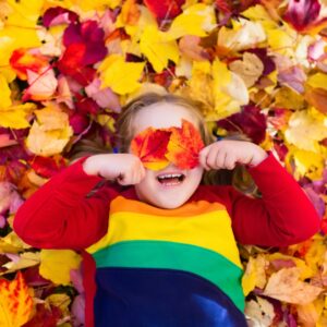Toddler laying in leaf pile