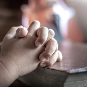 Praying hands on a bible