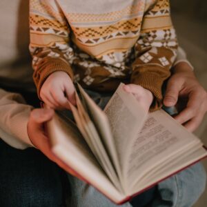 Child reading bible with parent
