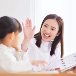 Preschooler Teacher high-fiving student 