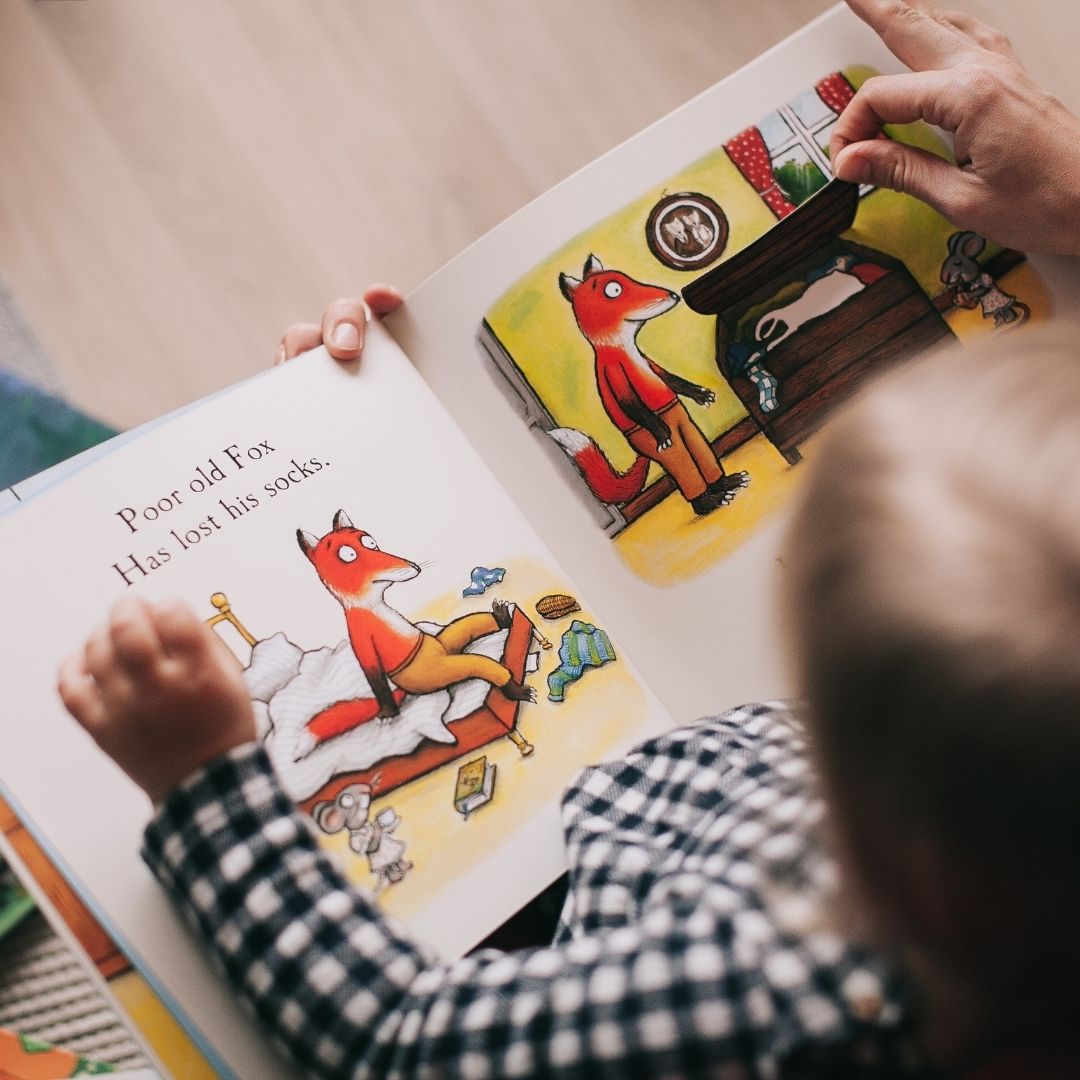 toddler reading with teacher