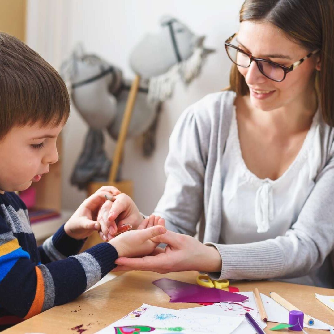 Teacher helping students with craft project